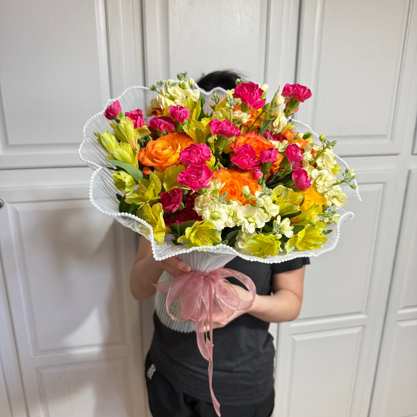 Large, vibrant mixed flower bouquet with orange, pink, yellow, and white blooms.