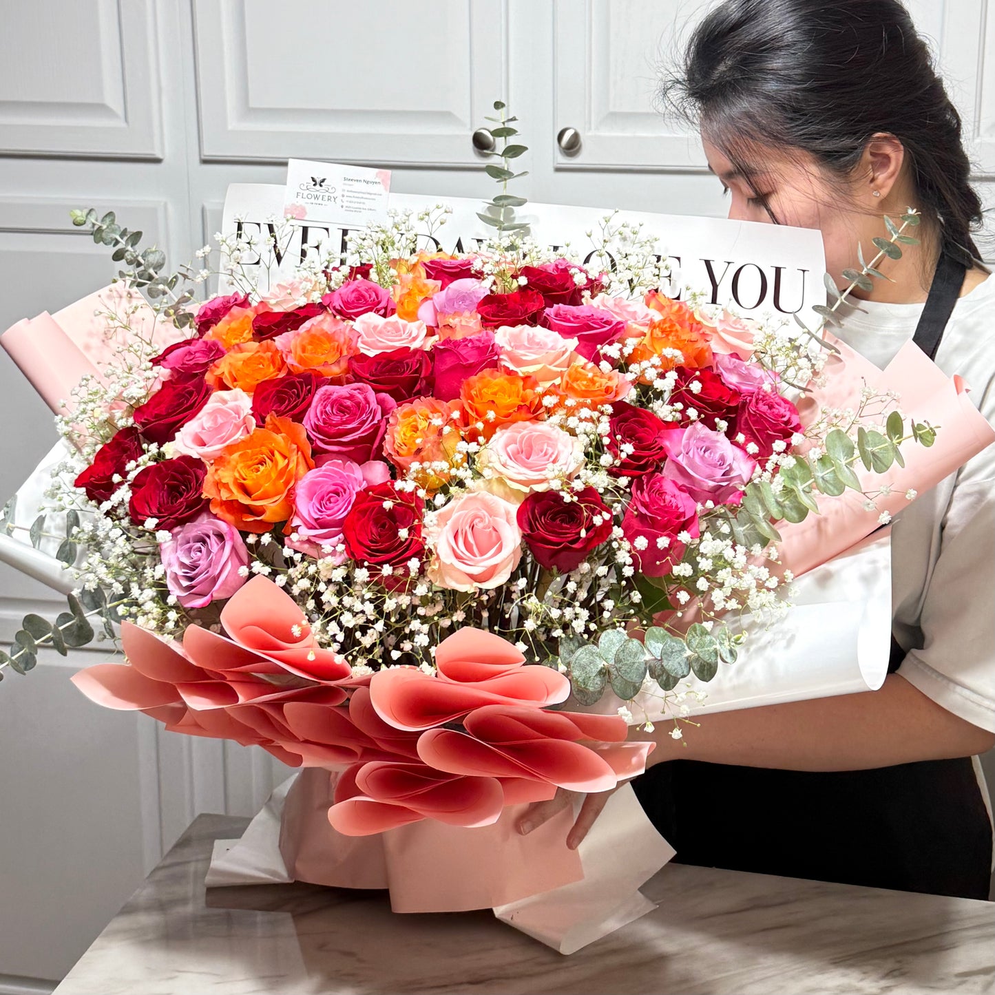 A large, vibrant bouquet of multi-colored roses and baby's breath.