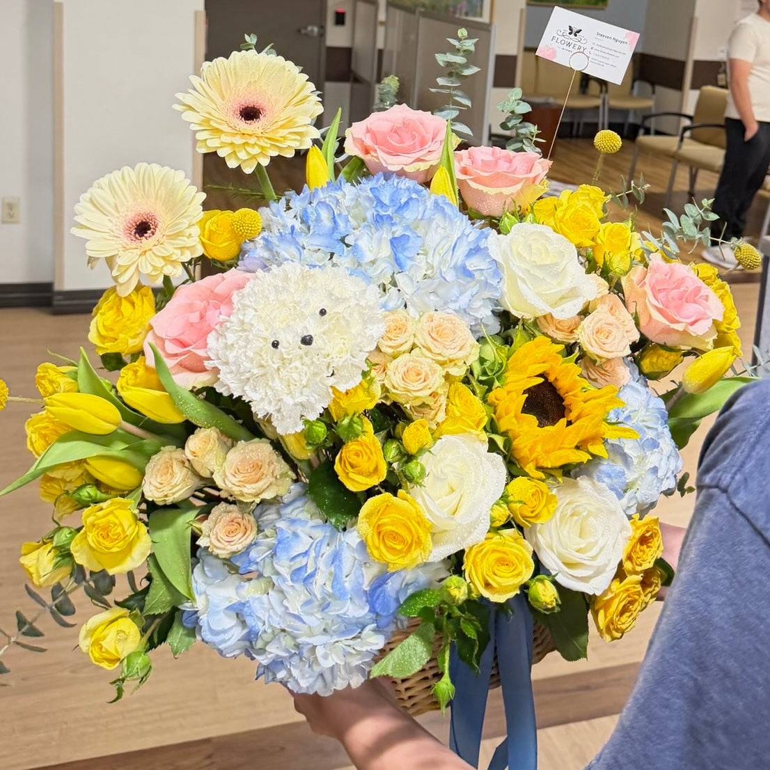 Vibrant Easter floral basket with yellow, blue, pink flowers and a white dog.