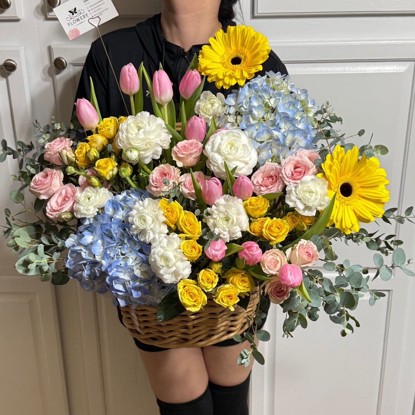 Large Easter flower basket with pink, yellow, blue, and white blooms.