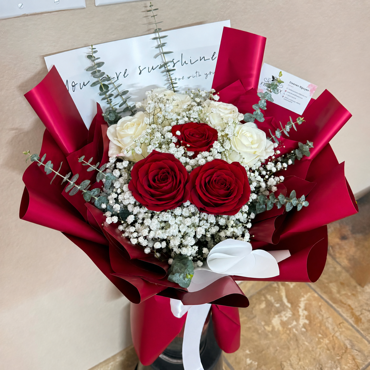 A dreamy bouquet of red and white roses with baby's breath and eucalyptus.