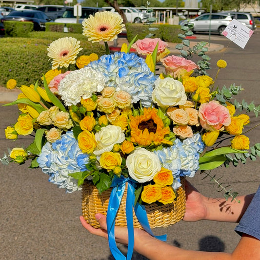 Colorful flower basket with yellow, blue, pink, and white blooms.